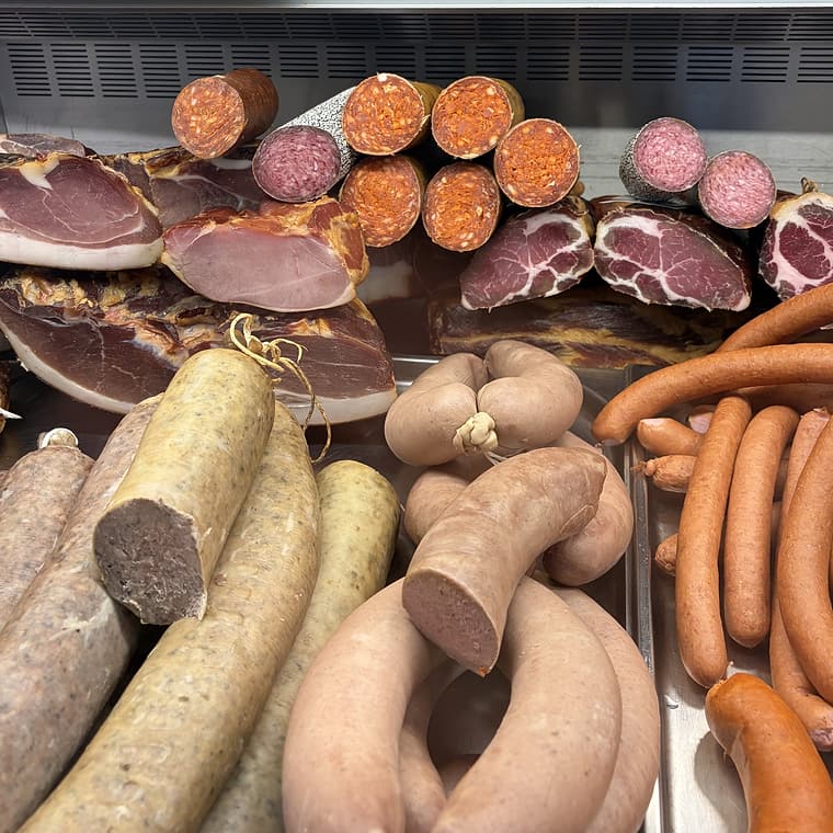 Füstölt sonka, szalámi, hurka és virsli a pultban